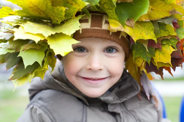 Porträtt av vackra pojke i krans från lämnar — Stockfoto