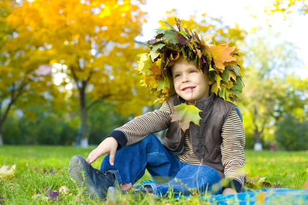 Retrato de niño hermoso en corona de hojas de otoño — Foto de Stock