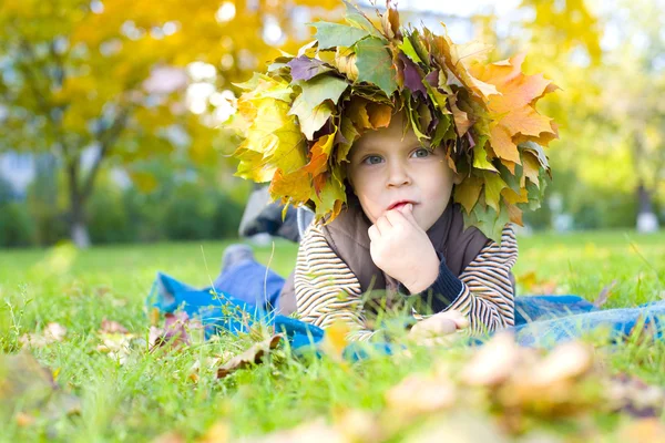 Porträt eines schönen Kindes im Kranz aus Herbstblättern — Stockfoto