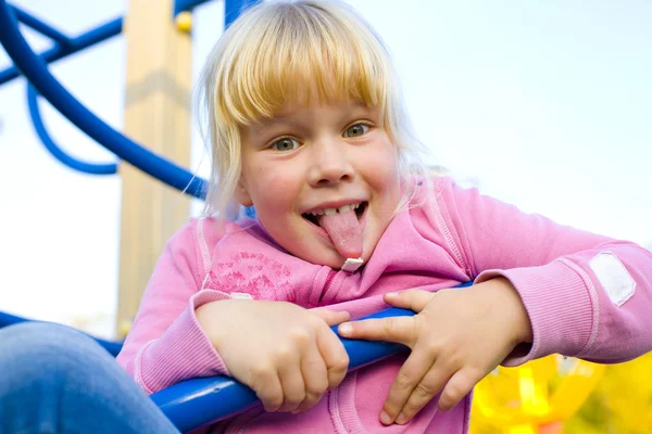 Graciosa niña de seis años muestra la lengua —  Fotos de Stock