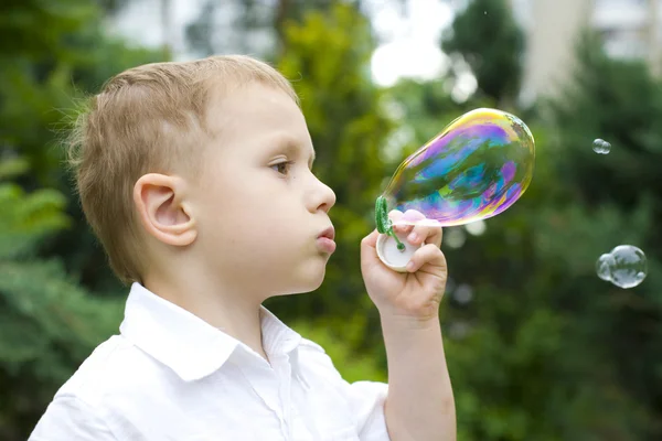 Four-year-old child plays with soap bubbles — Stock Photo, Image