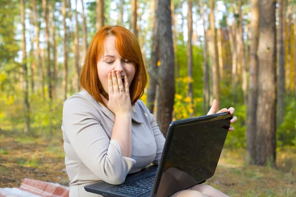 Känslomässiga rödhåriga flickan med den bärbara datorn — Stockfoto