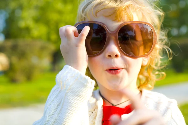 Lächerliches kleines Mädchen setzt große Sonnenbrille auf — Stockfoto