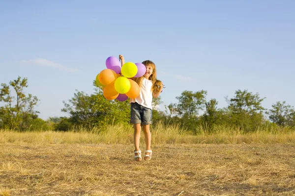 Funny little girl with balloons, bouncing — Stock Photo, Image