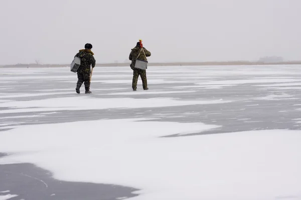 Fischer gehen im Winter fischen Stockbild