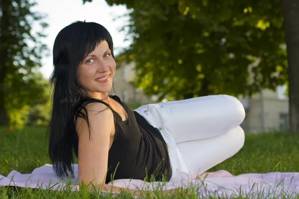 Girl-brunette on a grass — Stock Photo, Image