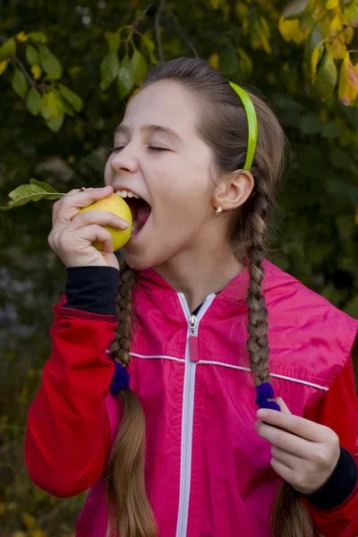 Porträtt av flicka med flätor och ett äpple — Stockfoto