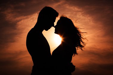 Couple in love silhouette during sunset - touching noses clipart