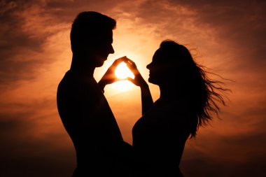 iki aşk siluet sırasında günbatımı - dokunmadan eller içinde