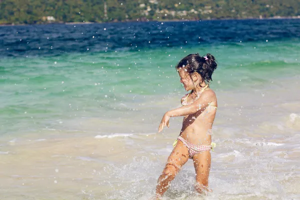 Chica corre en el agua en un aerosol Fotos De Stock