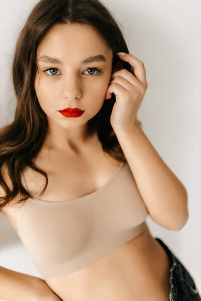 Πορτρέτο ενός όμορφου ελκυστικού γυναικείου μοντέλου σε μπεζ μπλουζάκι σε λευκό φόντο — Φωτογραφία Αρχείου