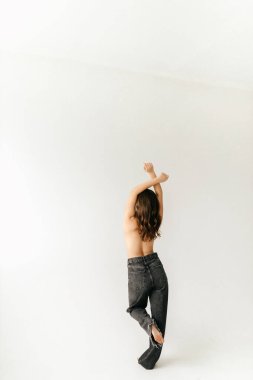 Gri kotlu dudaklarında kırmızı ruj olan sütyensiz seksi esmer.