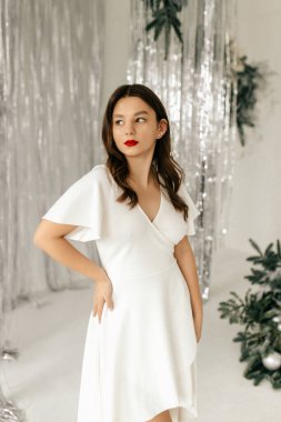 Stüdyoda poz veren beyaz elbiseli manken.
