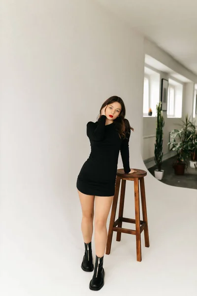 Gadis Muda Dalam Gaun Hitam Berpose Dengan Kursi Studio Foto — Stok Foto