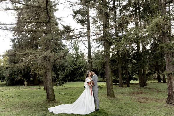 Beautiful wedding couple hugging in the forest — стоковое фото