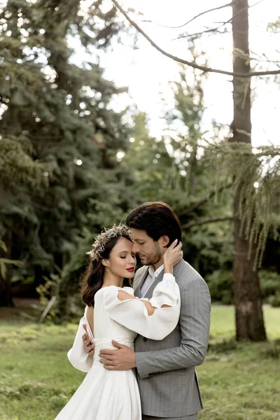 Young beautiful wedding couple hugging in the forest. Lovely couple, bride and groom posing, lifestyle — Fotografia de Stock