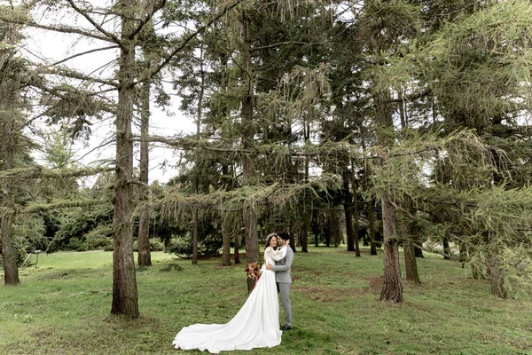 Glada par nygifta kramas i skogen efter bröllopsceremonin — Stockfoto