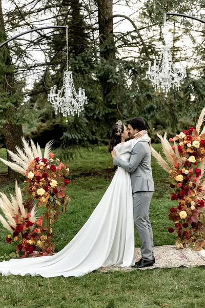 Recém Casados Atraentes Beijando Cerimônia Casamento Perto Arco Floresta Foto — Fotografia de Stock