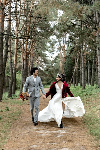 Cheerful Happy Newlyweds Run Holding Hands Smiling High Quality Photo — стоковое фото