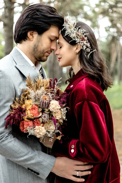 Beautiful young wedding couple hugging and walking in a pine forest. High quality photo