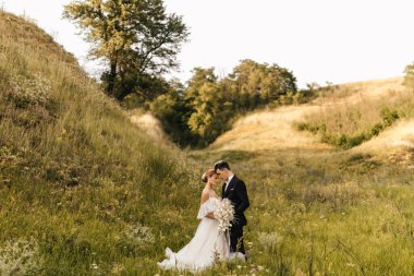 Genç ve çekici bir çift bir arada duruyor ve arka planda birbirlerine sarılıyorlar. Yüksek kalite fotoğraf