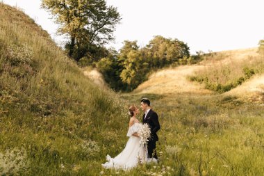 Genç ve çekici bir çift bir arada duruyor ve arka planda birbirlerine sarılıyorlar. Yüksek kalite fotoğraf