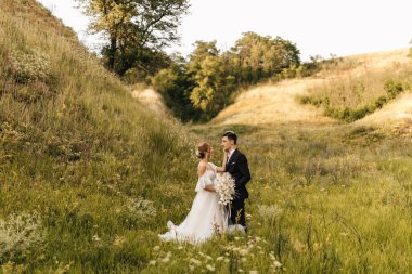 Genç ve çekici bir çift bir arada duruyor ve arka planda birbirlerine sarılıyorlar. Yüksek kalite fotoğraf
