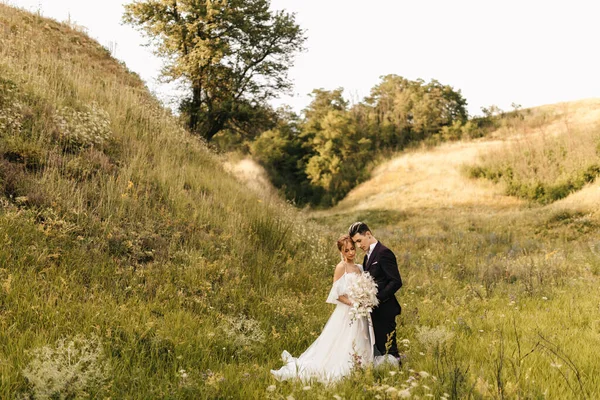 Genç ve çekici bir çift bir arada duruyor ve arka planda birbirlerine sarılıyorlar. Yüksek kalite fotoğraf