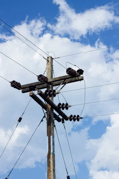 Poste eléctrico por la carretera con cables de línea eléctrica, contra azul — Foto de Stock