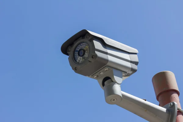 Mavi gökyüzü arkaplanındaki güvenlik kamerası — Stok fotoğraf