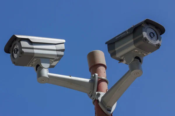 Dos cámaras de seguridad sobre fondo azul del cielo — Foto de Stock