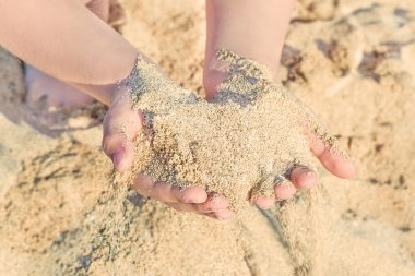 deniz kumu ile çocuğun elleri hurma