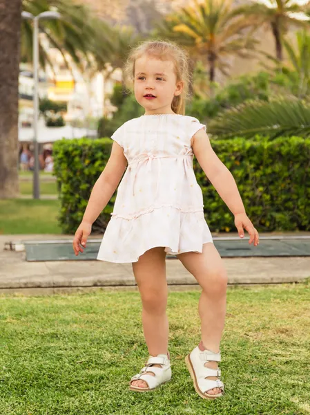 Menina dançando no gramado contra o fundo do parque Fotografia De Stock