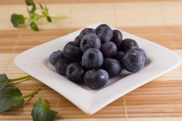 Kare şeklindeki bir plaka üzerinde lezzetli bilberries — Stok fotoğraf