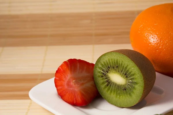 Aardbei en kiwi met grapefruit gesneden in de achtergrond — Stockfoto