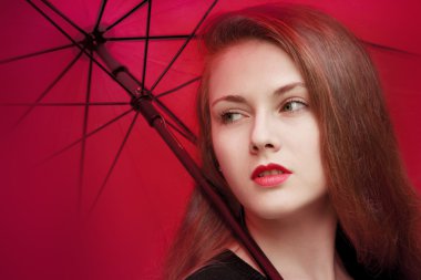 Kırmızı şemsiye altında duran kırmızı dudaklar ile kız