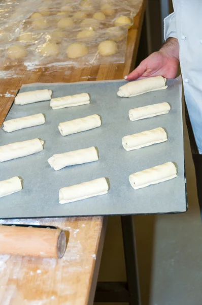 Bagare som bereder chokladcroissant — Stockfoto