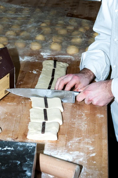 Baker preparing chocolate croissant — Stock Photo, Image
