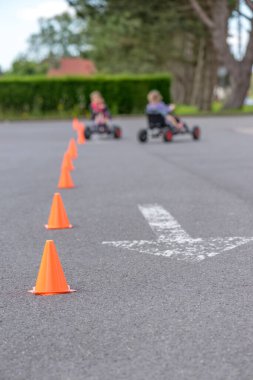 Çocuklar üzerinde pedal karting biniyor.