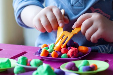 Küçük kız kille oynuyor.