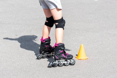 küçük kız sokakta Rollerblade yapıyor