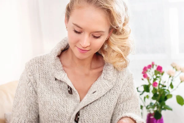 Portrait of a beautiful young woman. Woman sitting on the couch in the room. — Stock Photo, Image