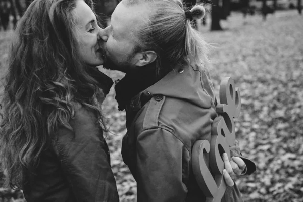 Love story. Autumn Park. Man and woman in a city park tells the story of his love. Black and white photography. — Stock Photo, Image