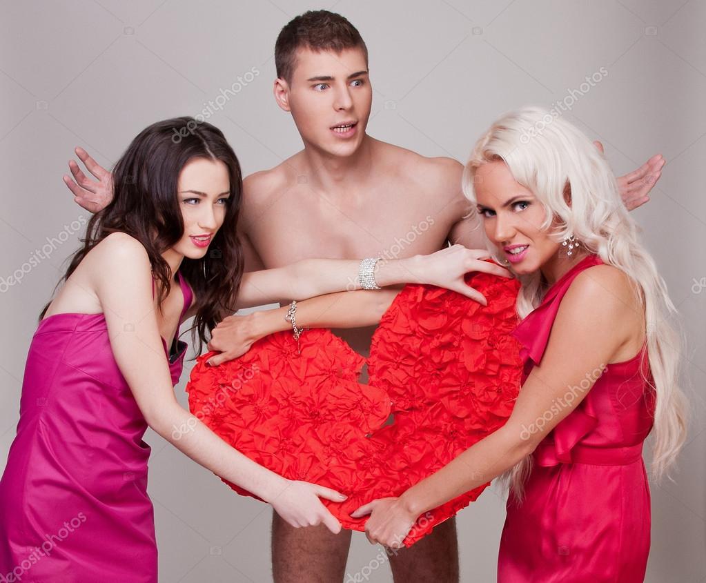 Two sexy girl holding a red heart as a symbol of love photo