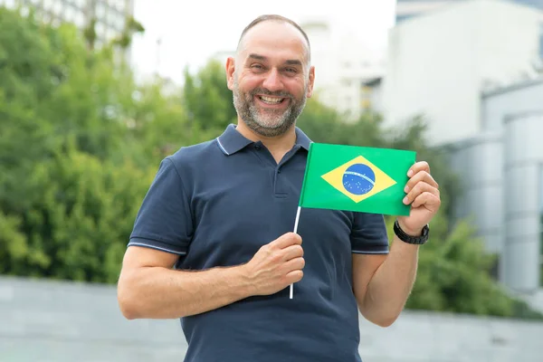 ブラジルの国旗を持った中年男性 サッカーファン 南米への旅行 — ストック写真