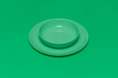 Yeşil arka planda tabağı olan yeşil yuvarlak boş tabak. Bir restoran ya da diyet hakkında metin ekleniyor.