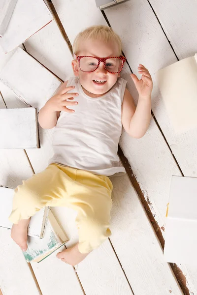 Chlapec na bílé malované podlahové — Stock fotografie