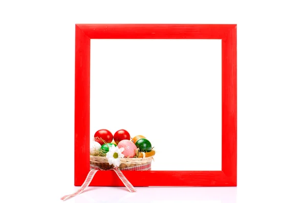 Painted wooden frame with basket of easter eggs — Stock Photo, Image