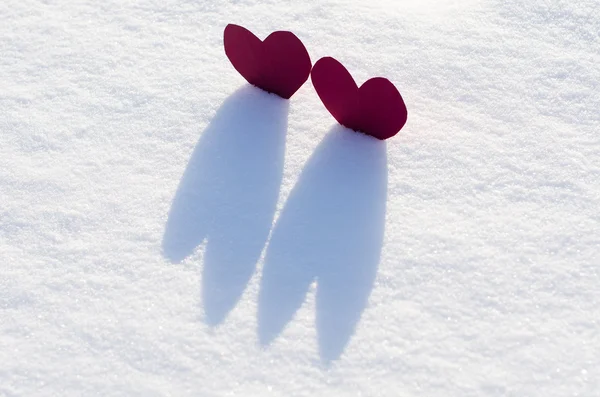 Два красных сердца в снегу — стоковое фото