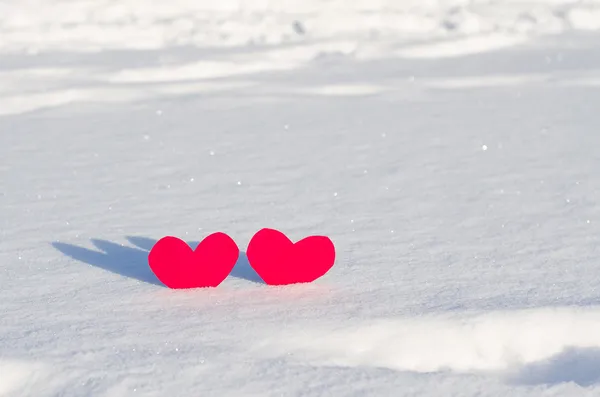 Twee rode harten in sneeuw — Stockfoto